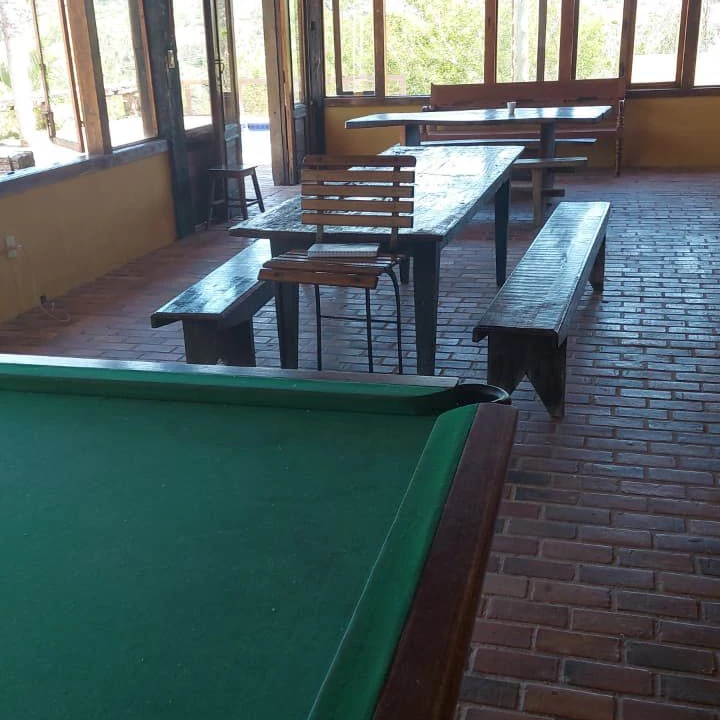 Clínica de recuperação em Sabará - MG Salão coberto com mesa de sinuca, mesas compridas e bancos de madeira